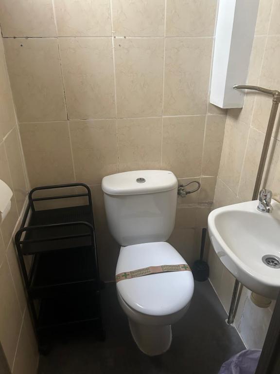 Un baño con un inodoro blanco y un lavabo. en Pensión LF - No Fumadores - Habitaciones Con Baño Privado - Sin Ascensor, en Zaragoza