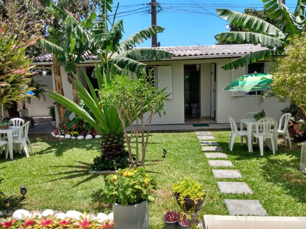 フロリアノポリスにあるCasa nos Ingleses - 1 quartoの白い椅子のある庭園