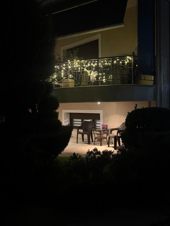 un balcón con luces en una casa por la noche en The root loft Trikala, en Tríkala