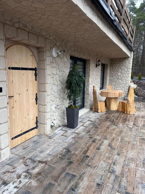 an outdoor patio with a wooden door and a table at Leśna Grota na Roztoczu in Górecko Stare