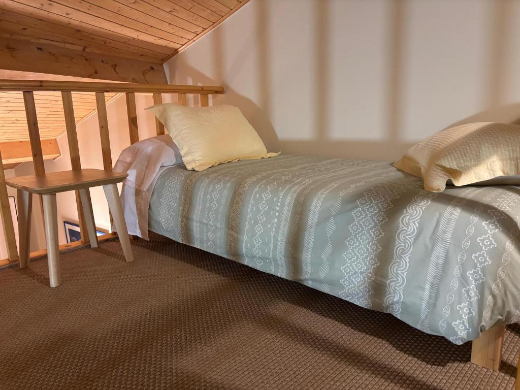 a bed in a room with a table and a bedskirtspectspectspectspects at O lar do Arroio in Allariz