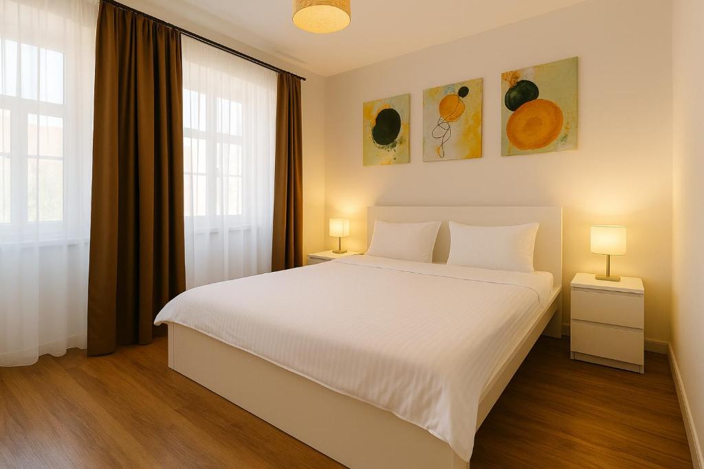 a bedroom with a large white bed and two lamps at Townhouse Boutique in Sibiu