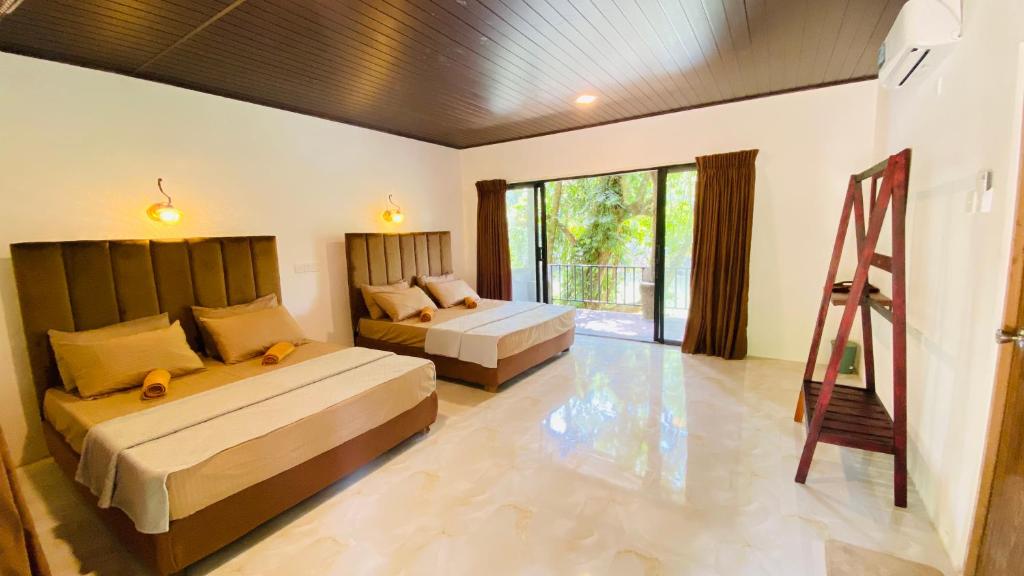 a bedroom with two beds and a ladder in it at Seravelle Kitulgala in Kitulgala