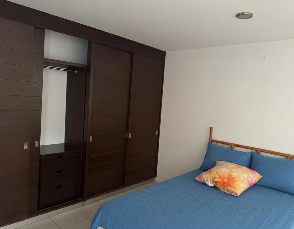 una camera con letto blu e armadio di Apartamento Atzompa Oaxaca a Città di Oaxaca