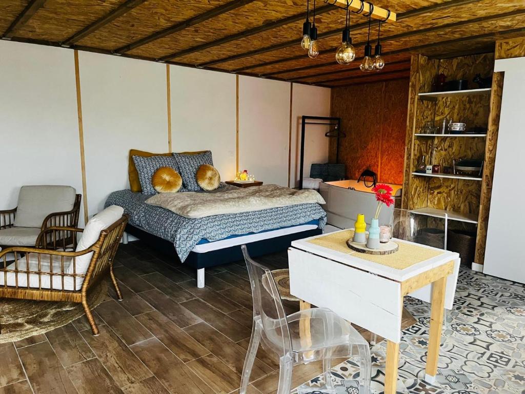 a bedroom with a bed and a table and chairs at Le chalet à bulles in Sainte-Marie-au-Bosc