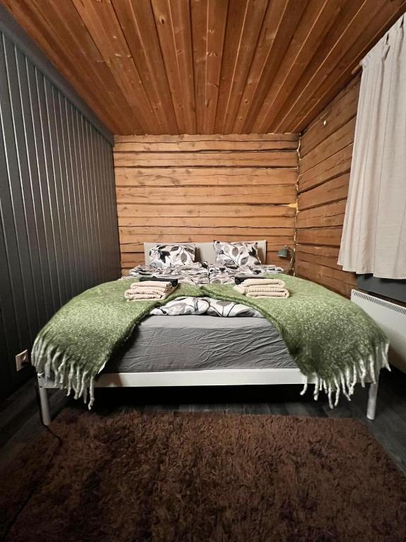 a bedroom with a large bed with a wooden wall at Kotkanpesä in Ylläs