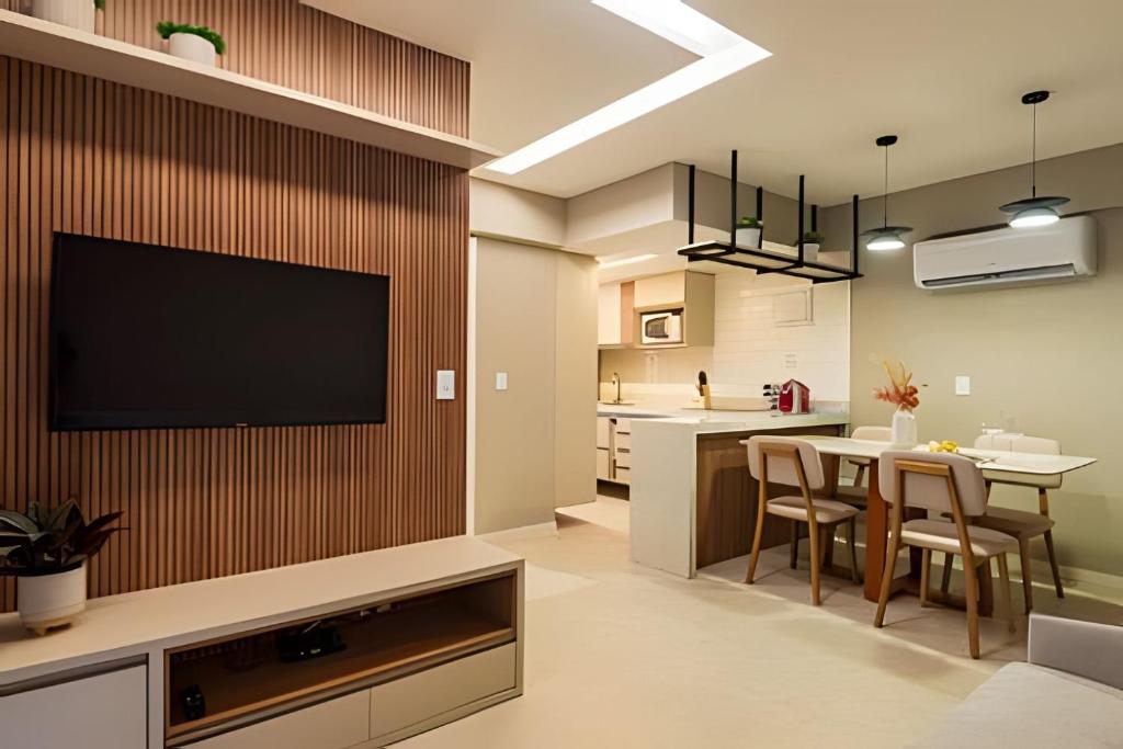 uma cozinha e sala de estar com uma TV de tela plana na parede em Mont Blanc Apartamentos em Vinhais