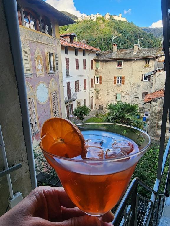 a drink sitting on a balcony with a view at Villa Coccodrilla Varallese in Varallo