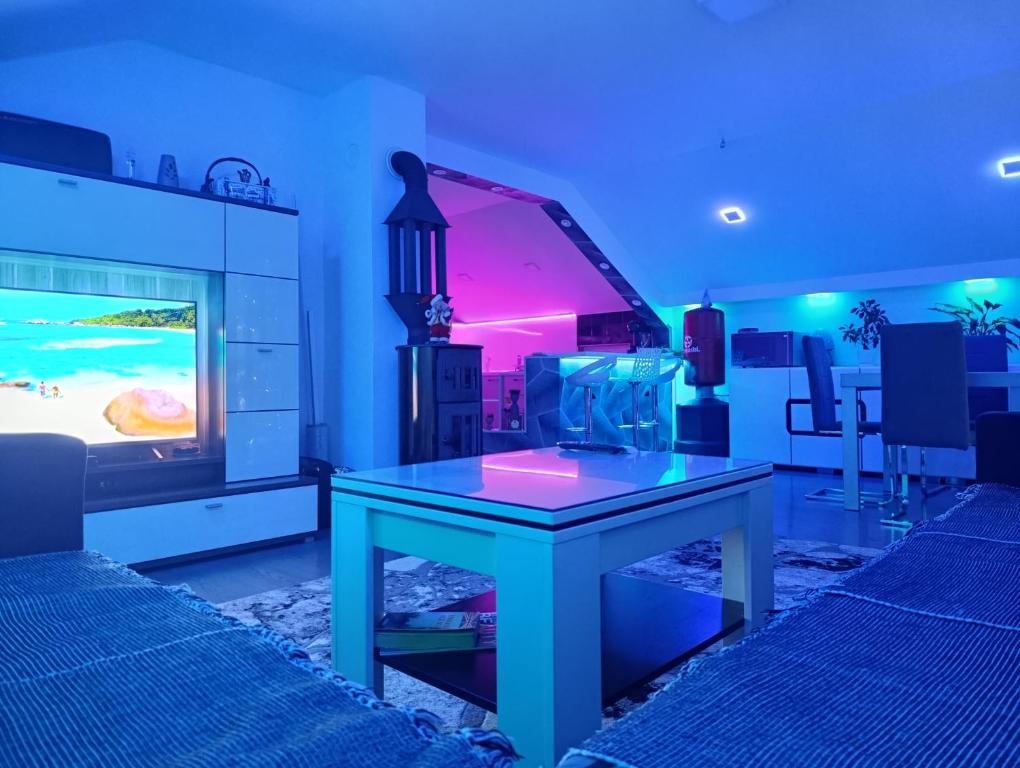 a living room with a table in front of a tv at Ambient Light apartment Sarajevo with free parking in Sarajevo