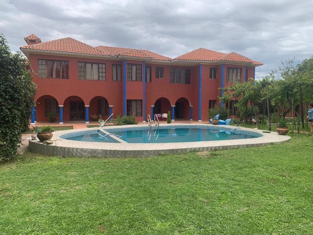 een groot huis met een zwembad ervoor bij Hotel San Javier in San Luis
