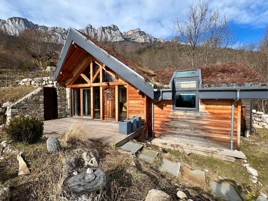 une cabane en rondins avec des montagnes en arrière-plan dans l'établissement Le Nid des Roches, à Saint Michel la Bâtie