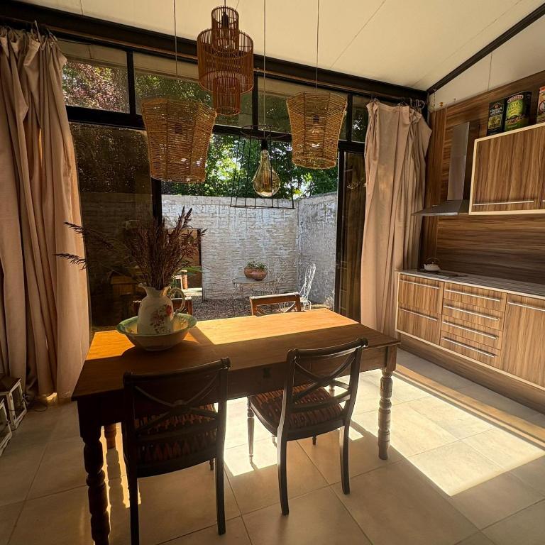 a dining room with a table and chairs and a kitchen at loft de diseño in Paysandú