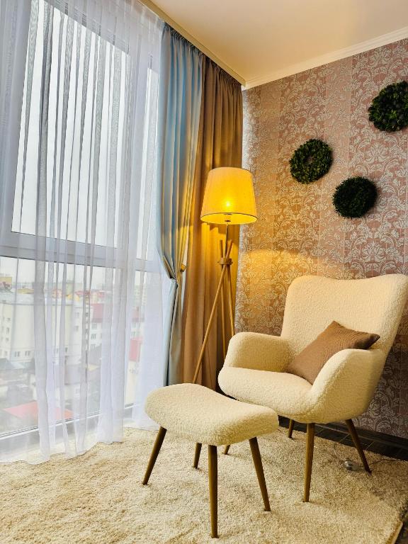 een woonkamer met een stoel, een lamp en een raam bij 2 rooms apartment central part in Ternopilʼ