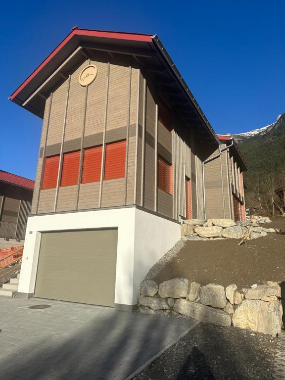 a building with a garage with a clock on it at Silenen Chalet I Andermatt I Ski I Berg I Familie in Silenen