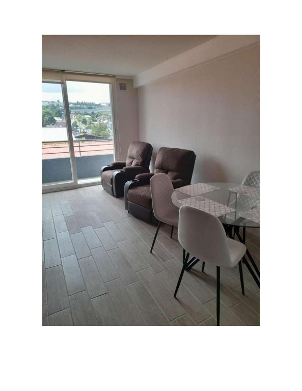 een woonkamer met twee stoelen en een tafel bij Condominio Vista Reloncavi in De Cauquenes