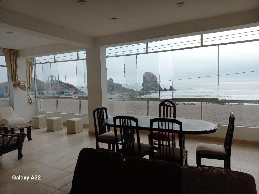 een eetkamer met een tafel en stoelen en uitzicht op het strand bij Beach House in Punta Negra