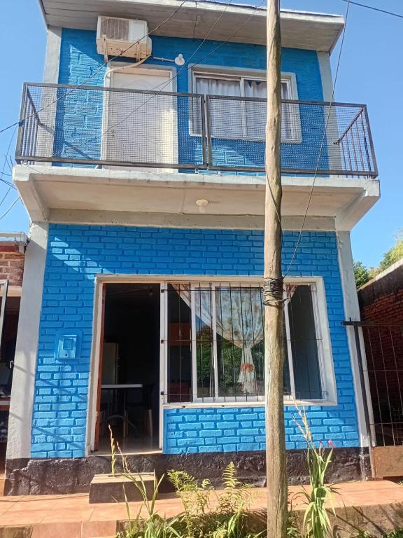 a blue house with a balcony at La Esperanza in Puerto Esperanza