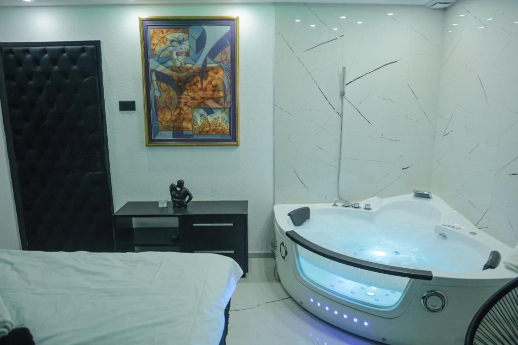 een badkamer met een bad en een bed. bij Tina apartman in Vranje