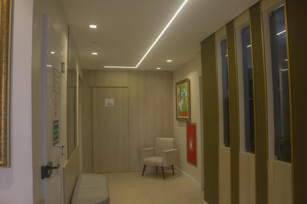 a hallway with a door and a chair in a room at Hotel Três Caravelas in Fortaleza