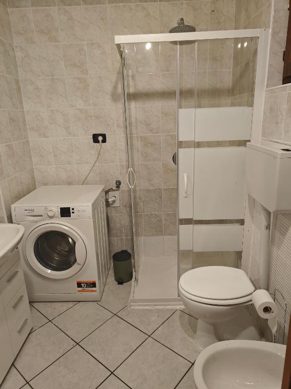 ein Badezimmer mit Waschmaschine und Toilette in der Unterkunft Bilocale vacanze in Borgo Ticino