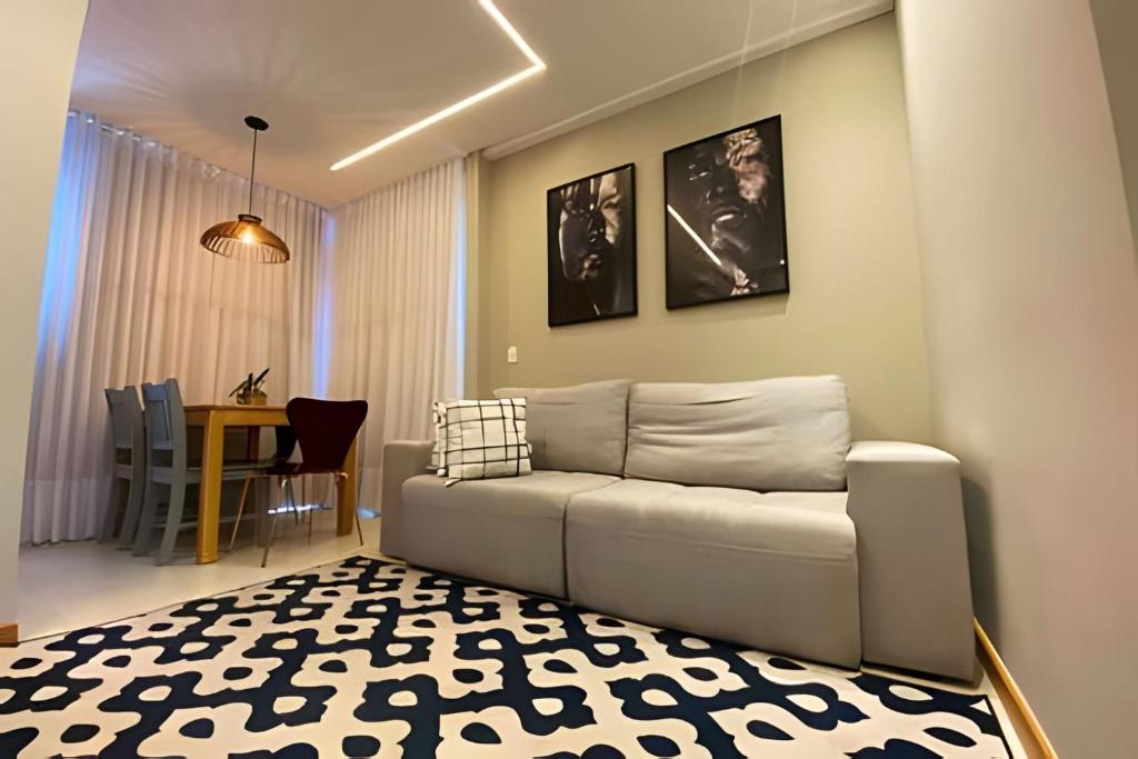 ein Wohnzimmer mit Sofa und Tisch in der Unterkunft PRAIA DE ITAPARICA BEACH 24HRS in Vila Velha