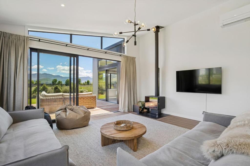 a living room with a couch and a table at Te Maunga Retreat | Views, Space & Near Ski Fields in Frankton