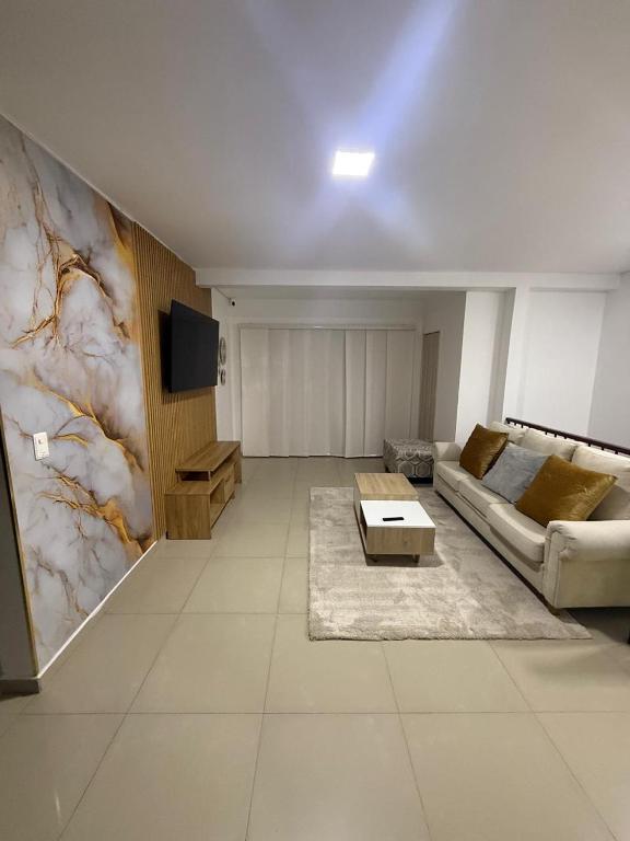 a living room with a couch and a tv at Lumière House in Medellín