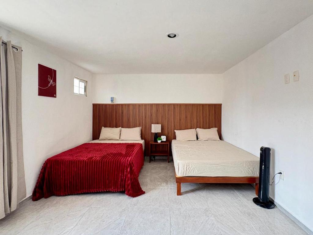 ein Schlafzimmer mit zwei Betten und einem Tisch darin in der Unterkunft Monet Hotel Motul in Motul de Felipe Carrillo Puerto