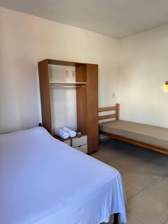 a bedroom with a bed and a bench in it at Studio Park e Mar a 600m do Beto Carrero in Penha