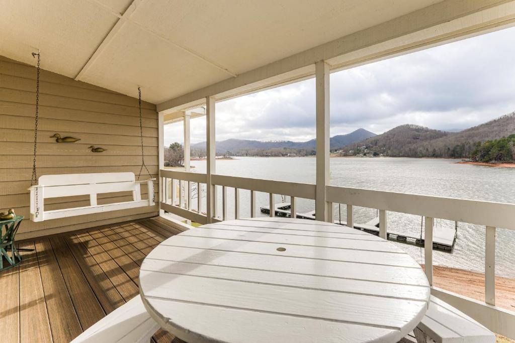 a porch with a table and a view of the water at Fire Pit and Boat Dock Lake Chatuge Townhome! in Hiawassee