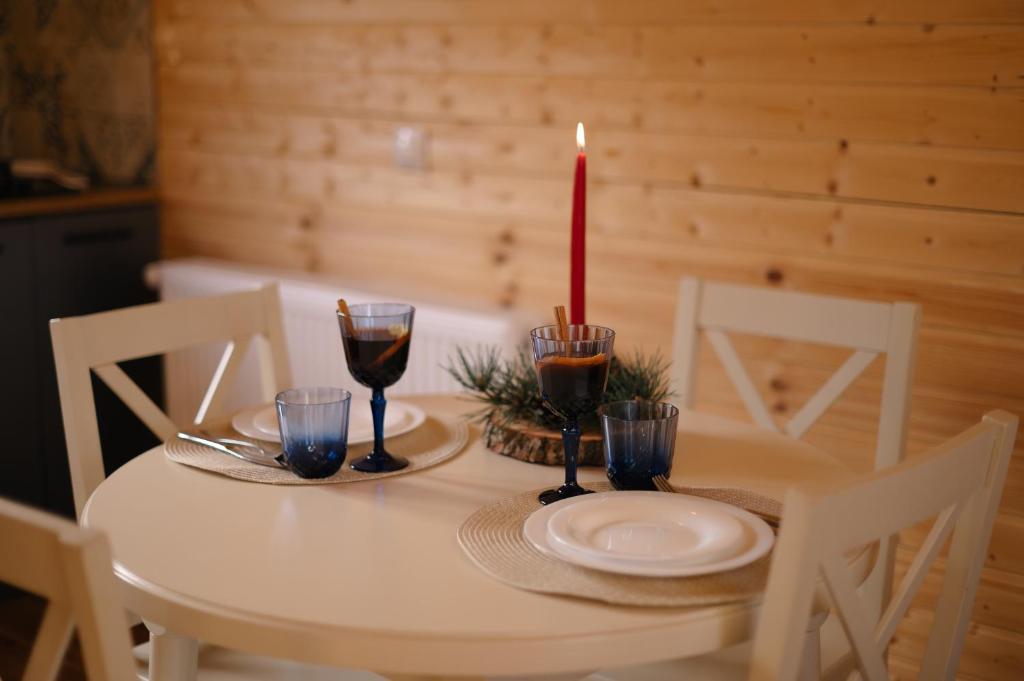 a white table with a candle and glasses on it at Kamara in Sioni