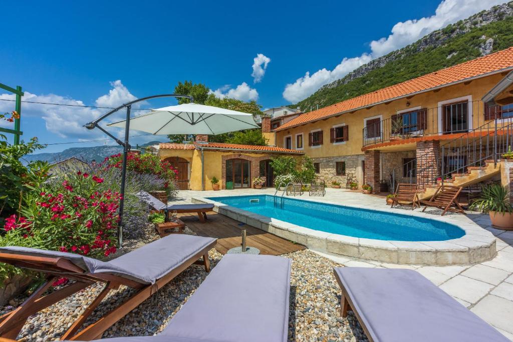 a home with a swimming pool and a house at Villa Natalia in Grižane