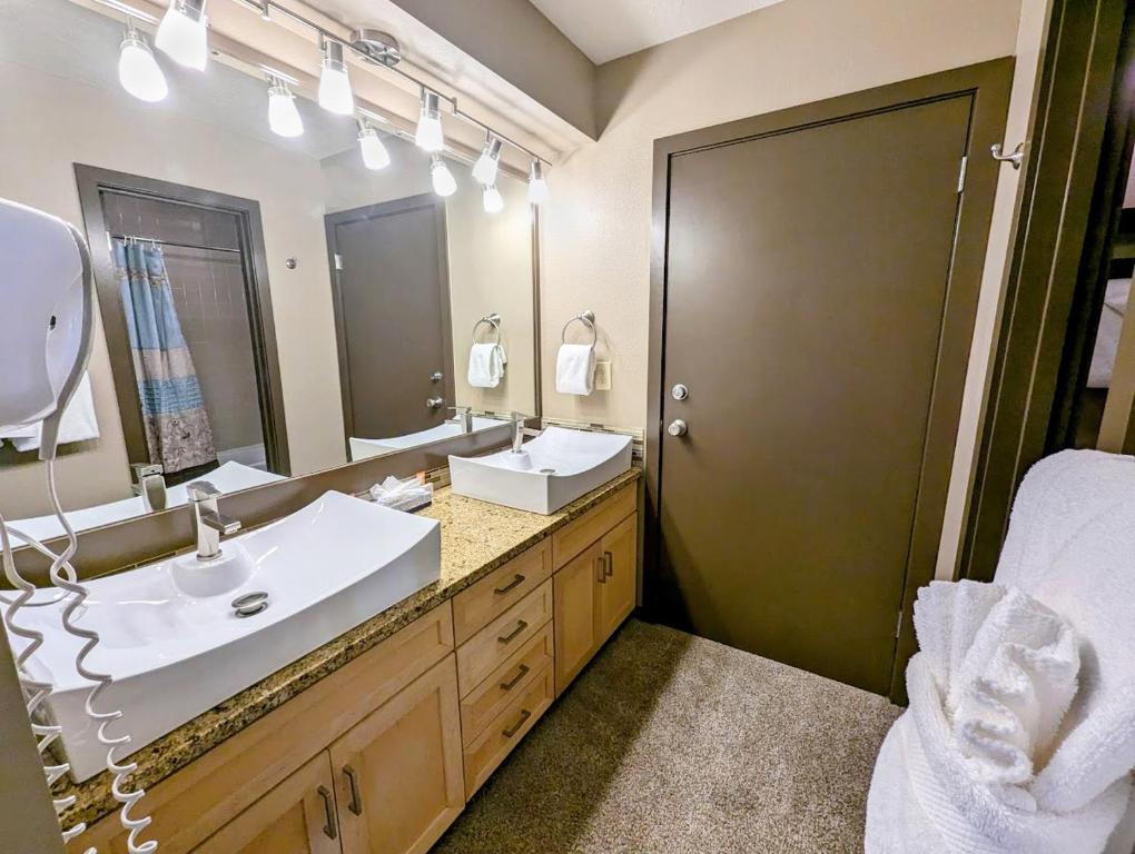 un bagno con due lavandini e un grande specchio di Quicksilver 1671 by SummitCove Lodging a Keystone