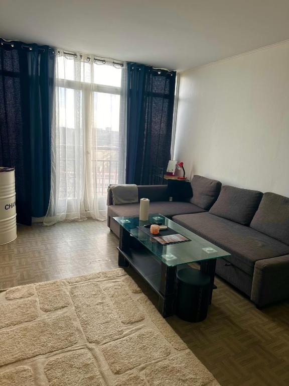 a living room with a couch and a coffee table at Apartament spațios și luminos in Savigny-sur-Orge