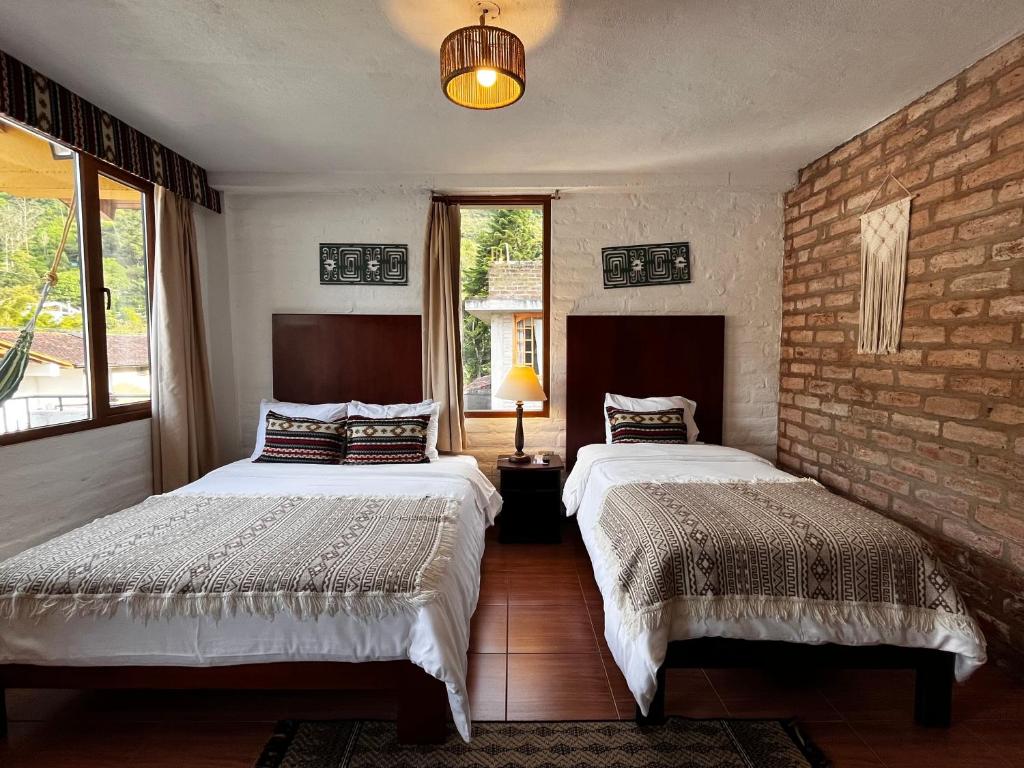 バーニョスにあるLa Floresta Hotelのレンガの壁、ベッド2台が備わるベッドルーム1室が備わります。