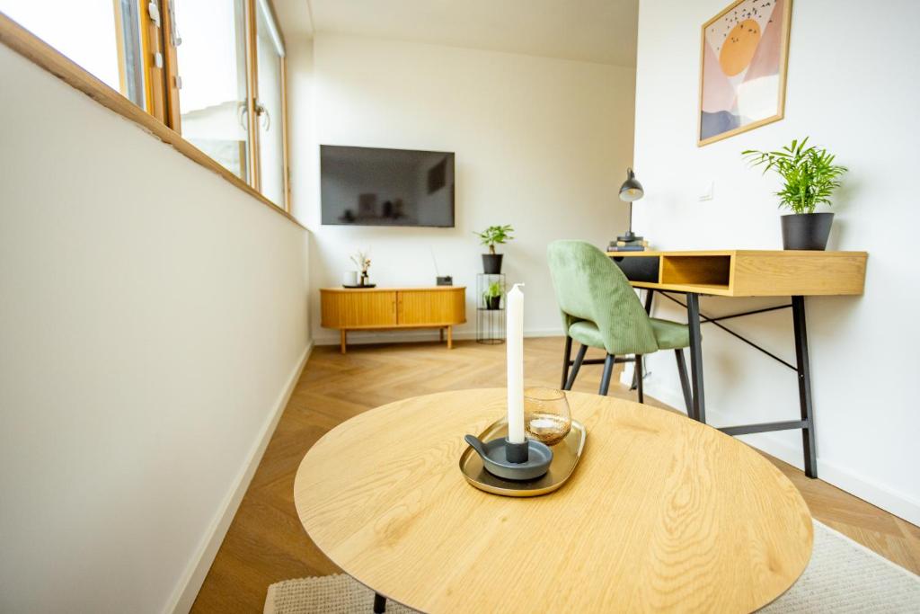 een woonkamer met een houten tafel en een bureau bij Fidelios Altstadt Appartements in Weiden