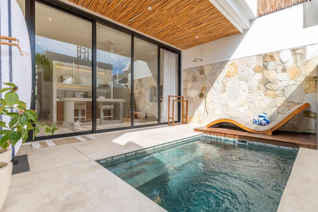 een binnenzwembad met een glijbaan in een huis bij Sore Pererenan Residence Unit 3 in Canggu