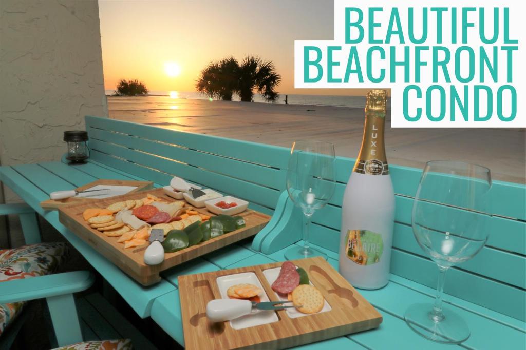 a table with a bottle of champagne and a plate of food at Beachfront Bliss 3BR Oceanfront Condo with Pool and Hot Tub in Myrtle Beach