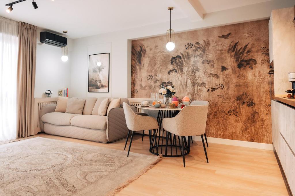 een woonkamer met een tafel en een bank bij Harmony North Two Bedroom in Boekarest