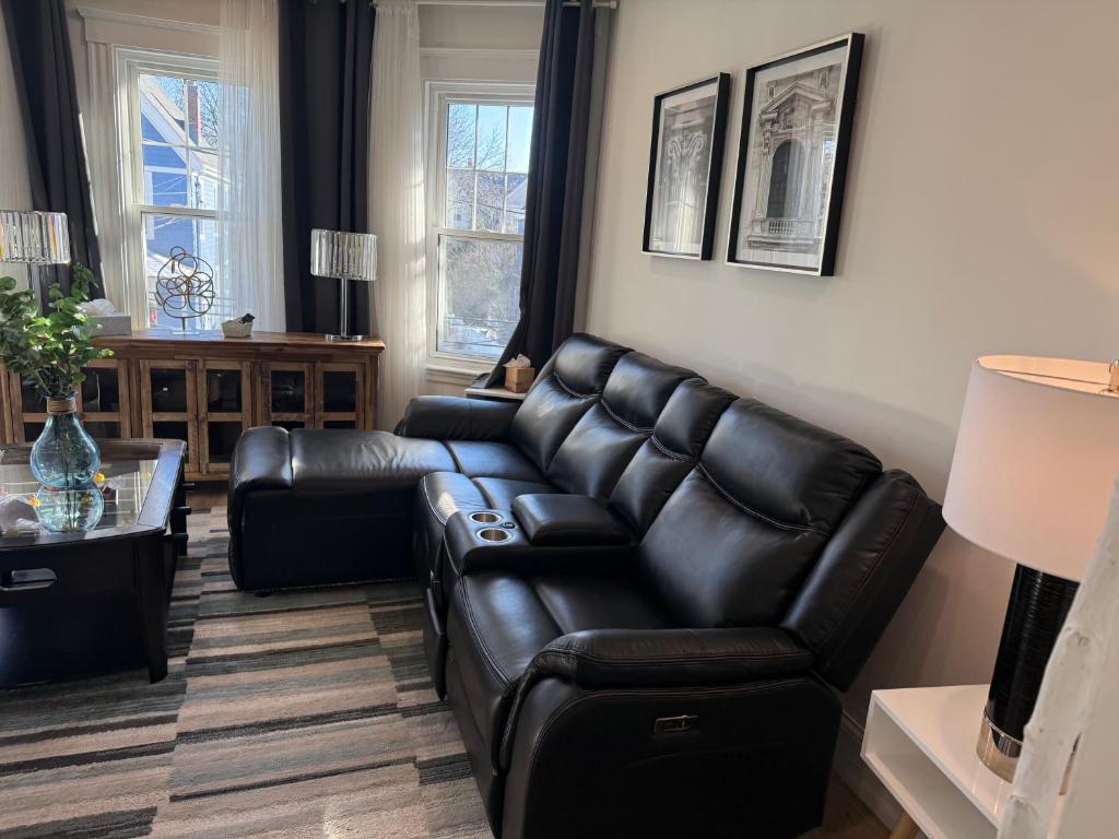 a living room with a leather couch and a table at Roslindale village condos in Boston