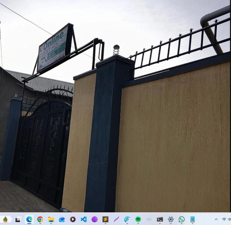 ein Schild auf dem Dach eines Gebäudes mit einer Tür in der Unterkunft OnlineGuest House Katete in Mbarara