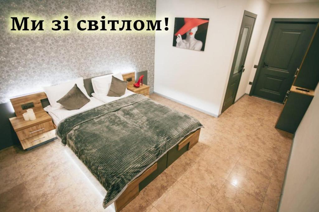 a bedroom with a bed with a green comforter at 4rooms in Vinnytsya