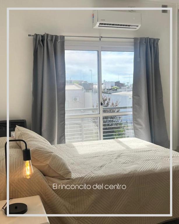 una camera da letto con un letto e una grande finestra di El Rinconcito del Centro a Concepción del Uruguay