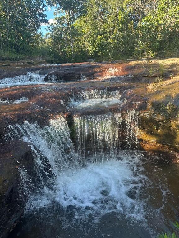 a waterfall on the side of a river at Pousada e Cachoeira Paraiso in Barra do Garças