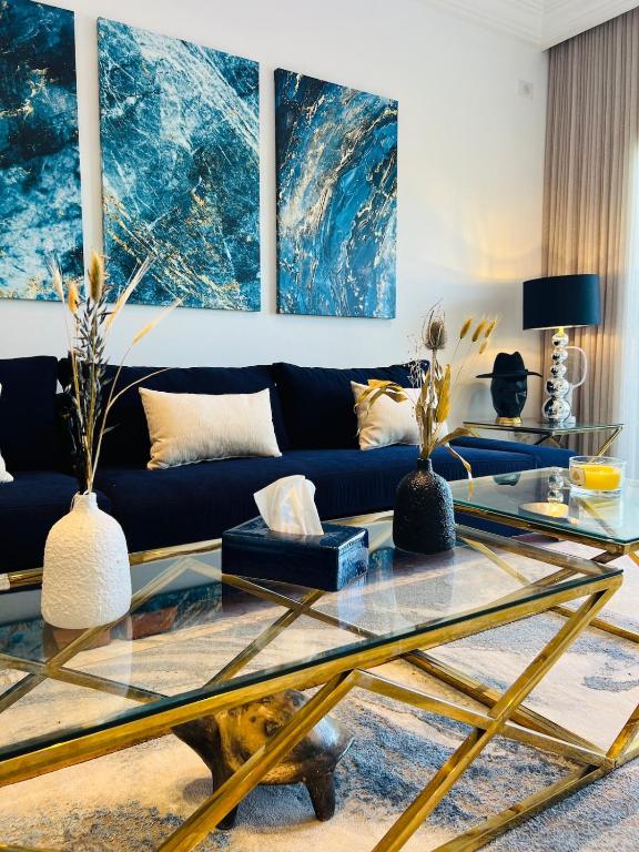 ein Wohnzimmer mit einem blauen Sofa und einem Glastisch in der Unterkunft Paradiso in Sidi Bou Saïd