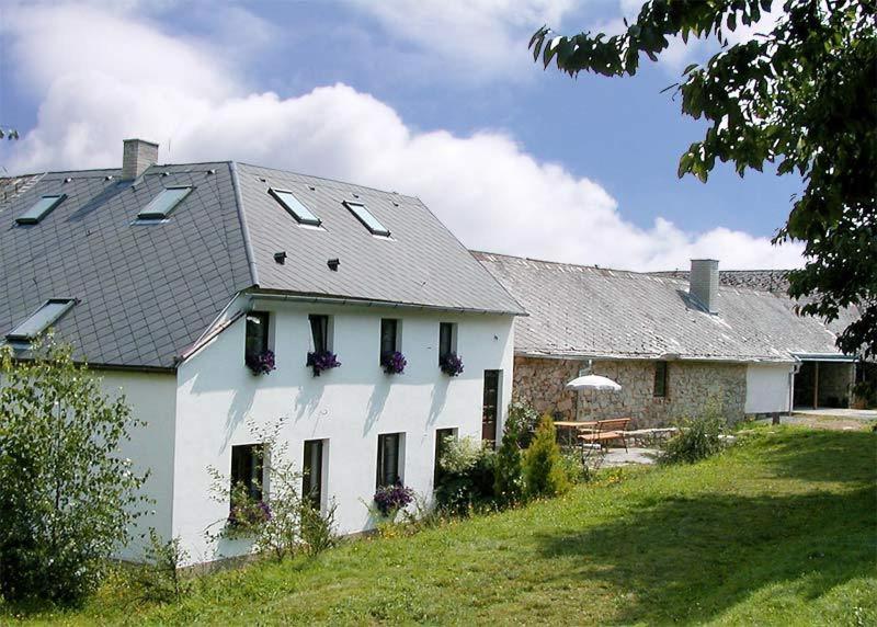 une maison blanche avec des fenêtres et un toit dans l'établissement Penzion Javořice, à Telč