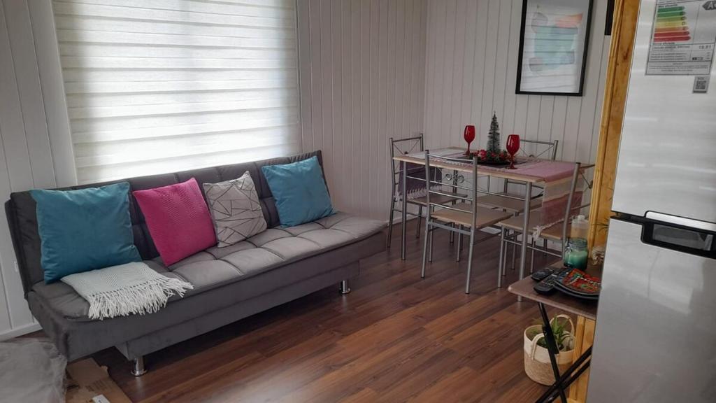 a living room with a couch with colorful pillows at Casa en Puerto Montt in Puerto Montt