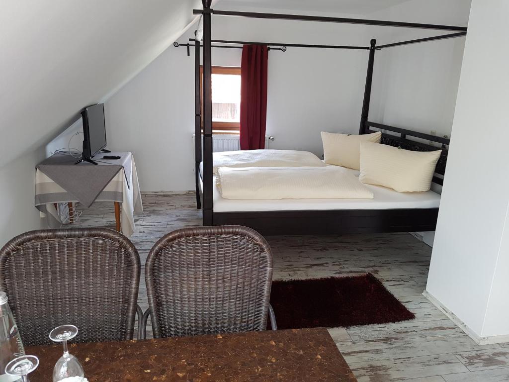 ガウティングにあるLandgasthof Hallerのベッドルーム1室(ベッド1台、椅子2脚、テーブル付)