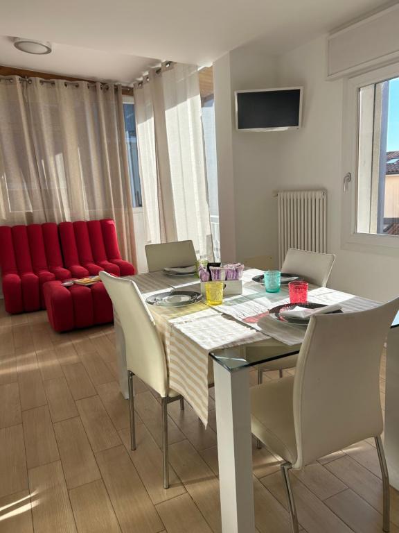 a dining room with a table and chairs and a red couch at Larocca Tourist Home 6 Bassano in Bassano del Grappa