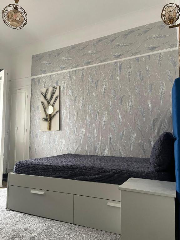 a bedroom with a bed with a gray wall at Studio tres calme Quartier administratif Rabat in Rabat
